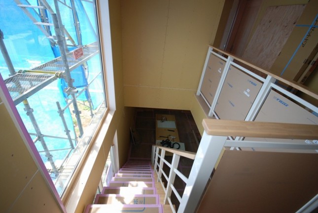埼玉県川口市のおしゃれな注文住宅。2階への階段まわり腰壁は明るいクリアパネルを採用